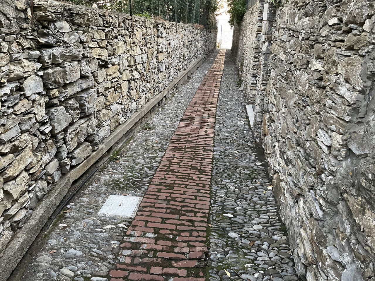 track, wall, the way forward, day, no people, architecture, railroad track, nature, road surface, transportation, walkway, footpath, cobblestone, outdoors, transport, built structure, high angle view, rubble, stone, rail transportation, plant, diminishing perspective, gravel, stone wall, tree, rock, wall - building feature, street