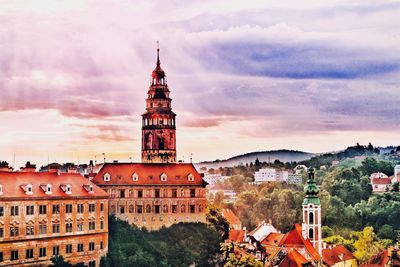 Buildings in town against cloudy sky