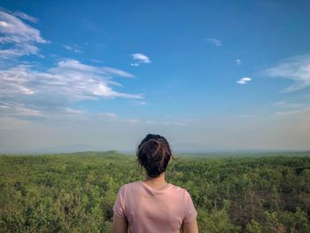 Rear view of woman looking at hill against sky