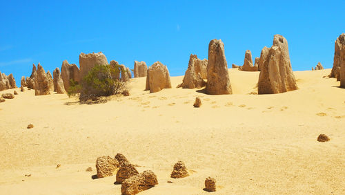 Panoramic view of desert against clear blue sky