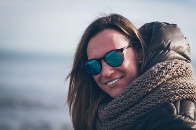 Portrait of smiling woman at beach during winter