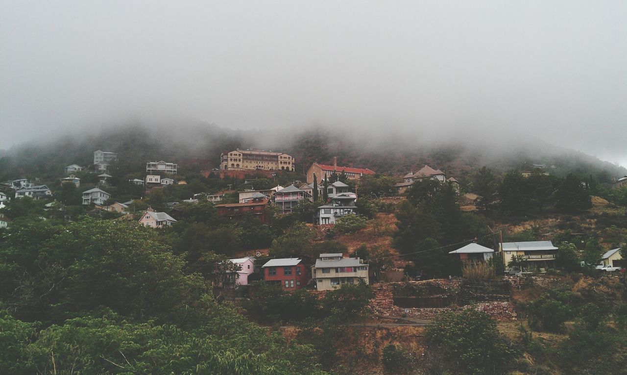 fog, building exterior, foggy, architecture, built structure, weather, house, mountain, residential structure, tree, sky, residential building, overcast, nature, landscape, high angle view, beauty in nature, tranquility, day, scenics