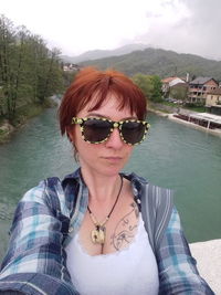 Portrait of young woman wearing sunglasses standing outdoors