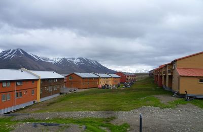 Houses by buildings against sky during winter