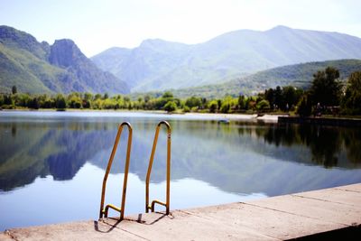 Scenic view of lake by mountains against sky