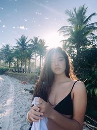 Portrait of young woman with palm tree