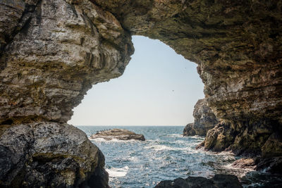 Rock formations by sea against sky