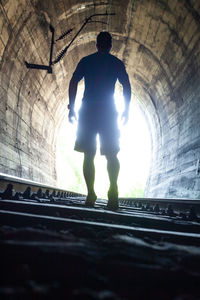 Rear view of silhouette man standing in corridor