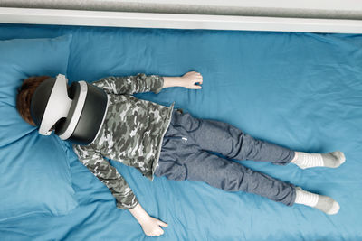 High angle view of man lying on bed at home