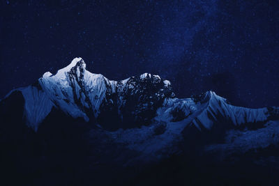 Scenic view of snowcapped mountains against sky at night