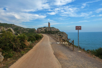 Road leading towards sea against sky