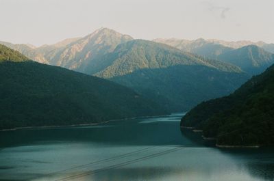 Scenic view of river amidst mountains against sky