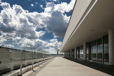 Empty road amidst buildings in city against sky