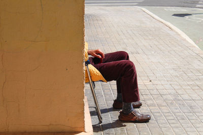 Man sitting on footpath