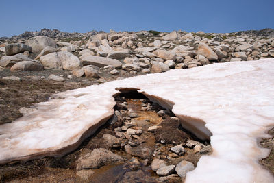 Rock formation on shore against sky