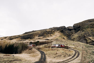 Cars on road by mountain against clear sky