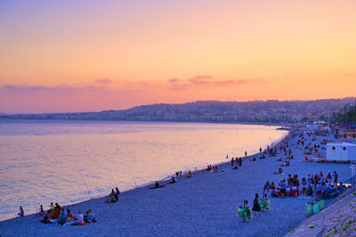 High angle view of people on beach against sky during sunset