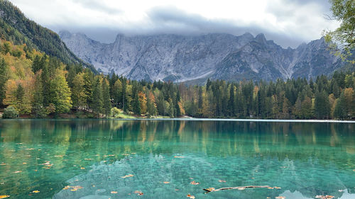 Scenic view of lake by mountains against sky