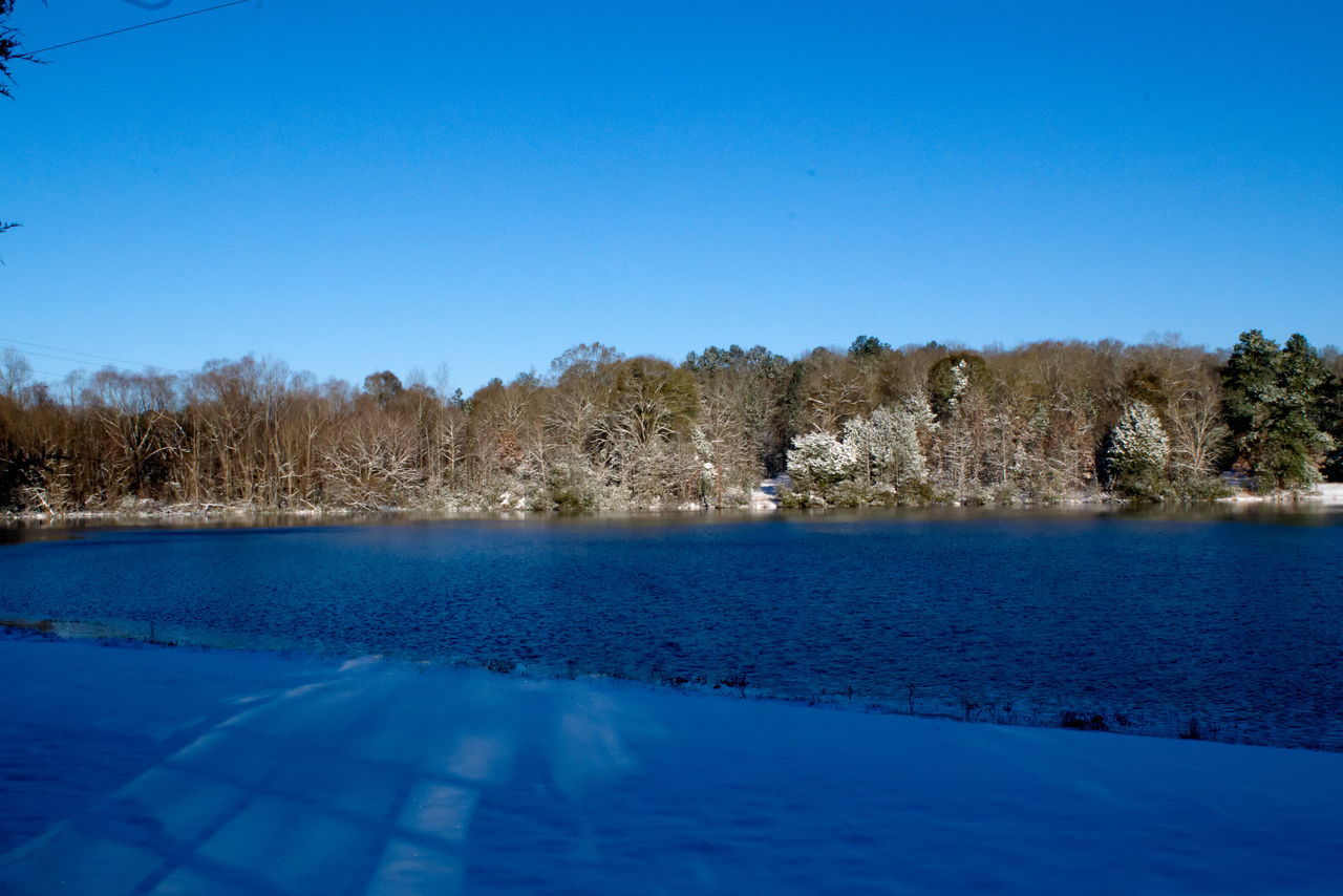 SWIMMING POOL BY LAKE AGAINST BLUE SKY