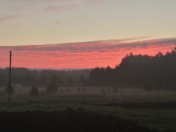 Scenic view of field against sky at sunset