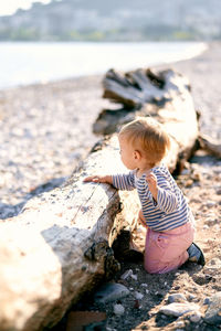 Boy on rock in shallow water