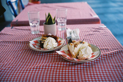 High angle view of pie slices served on checkered tablecloths 