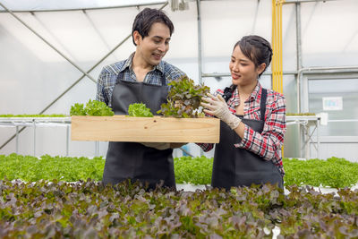 Woman standing in front of greenhouse