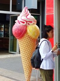 Woman holding ice cream cone in city