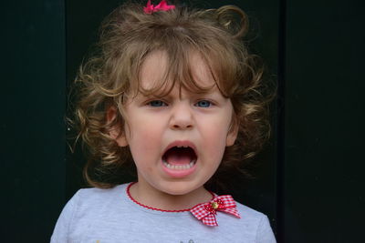 Portrait of cute sad girl screaming outdoors