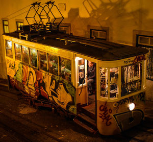 Train on illuminated railroad tracks in city at night