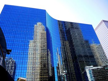 Low angle view of office building against blue sky