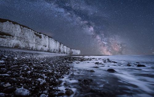 Scenic view of sea against star field at night