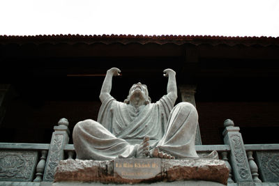 Statue of buddha against building