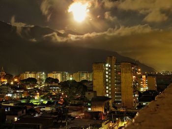 Illuminated cityscape against sky at night