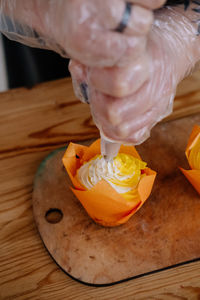 Cropped hand of woman holding food on table