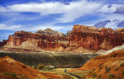 Rock formations on landscape against cloudy sky