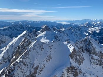 Aerial view of snow covered mountains against sky