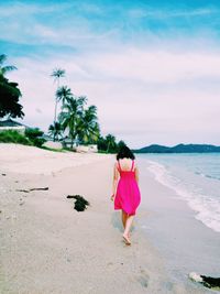 Rear view of woman walking on beach