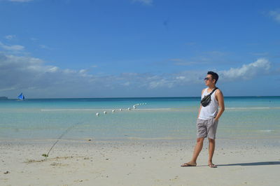 Full length of woman standing on beach against sky