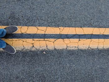 Low section of person standing on road