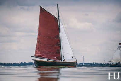 Sailboat sailing on sea against sky