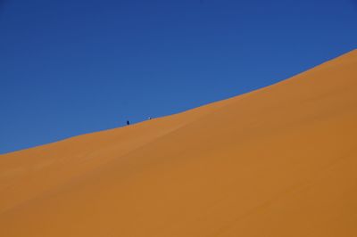 Scenic view of desert against clear blue sky