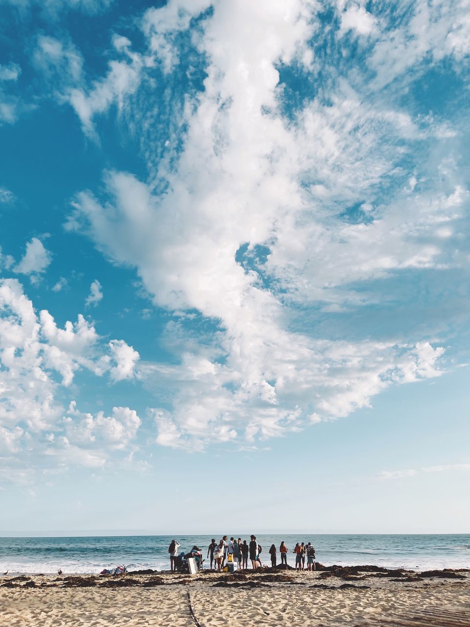 sky, sea, water, beach, land, horizon, cloud, body of water, ocean, shore, horizon over water, group of people, nature, holiday, beauty in nature, trip, vacation, scenics - nature, coast, sand, travel, travel destinations, blue, wave, summer, leisure activity, tourism, day, large group of people, outdoors, adult, crowd, men, tourist, women, sunlight, tranquility, environment, wind wave, lifestyles, tranquil scene, group, idyllic, coastline, copy space, motion, water's edge