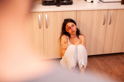 Portrait of young woman sitting on bed at home