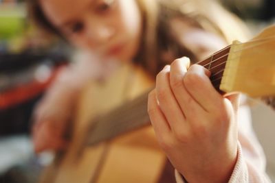 Close-up of girl playing guitar