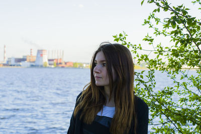 Young woman against trees