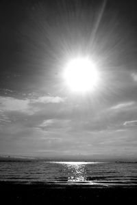 Scenic view of sea against bright sun