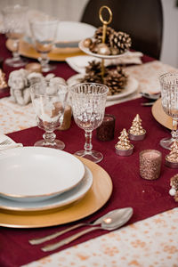 Top view of fork on napkin tied with thread placed near plated and crystal glasses on served table for christmas dinner