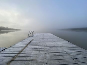 View from pier to misty water at sunrise