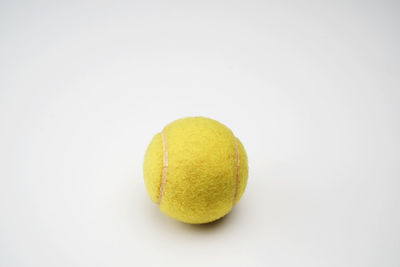 Close-up of yellow ball on white background